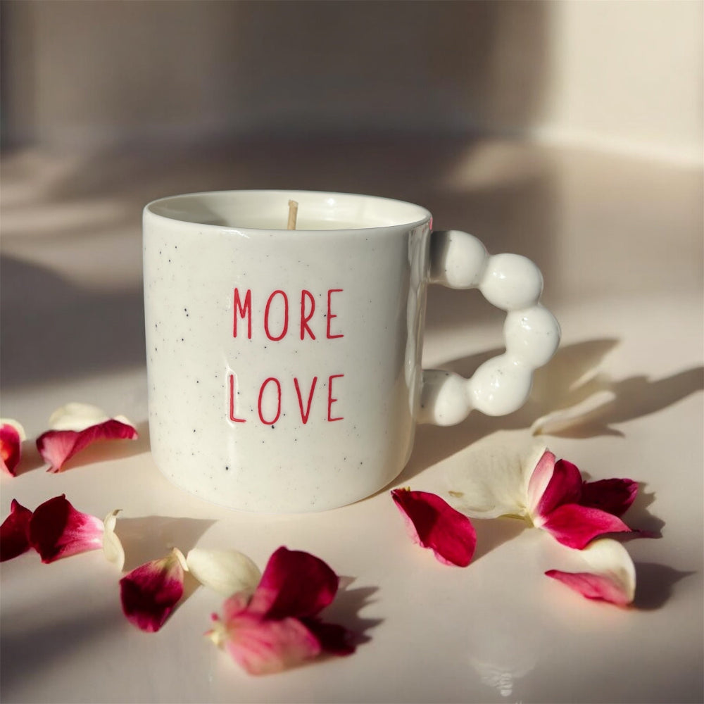 Bougie coulée dans une tasse en céramique de 340ml. Avec une inscription rouge "More Love". Parfumée Fleur de Coton